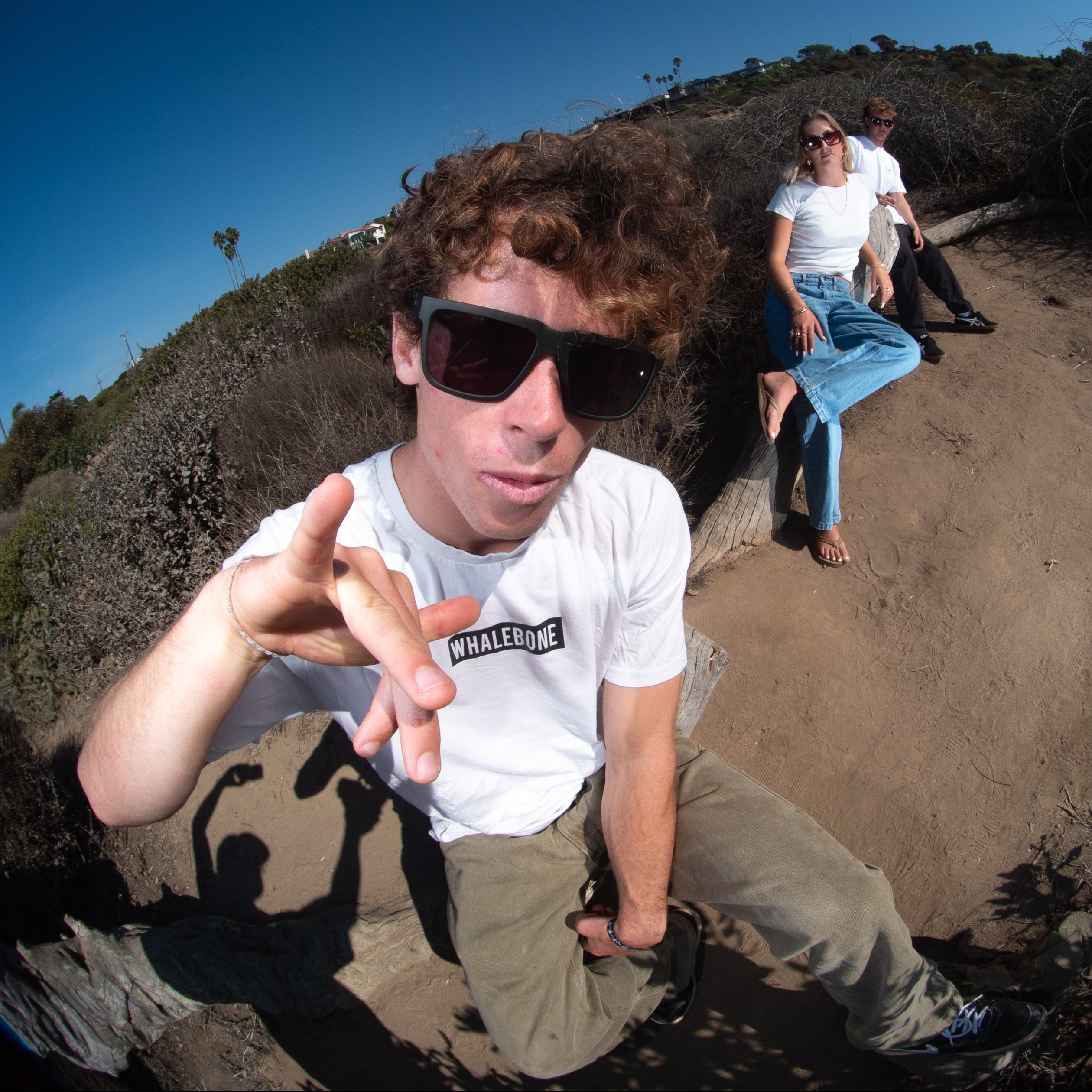 Person with sunglasses posing in a circular, fisheye-lens view of a desert landscape.