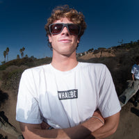 Man wearing sunglasses, standing on a coastal path.