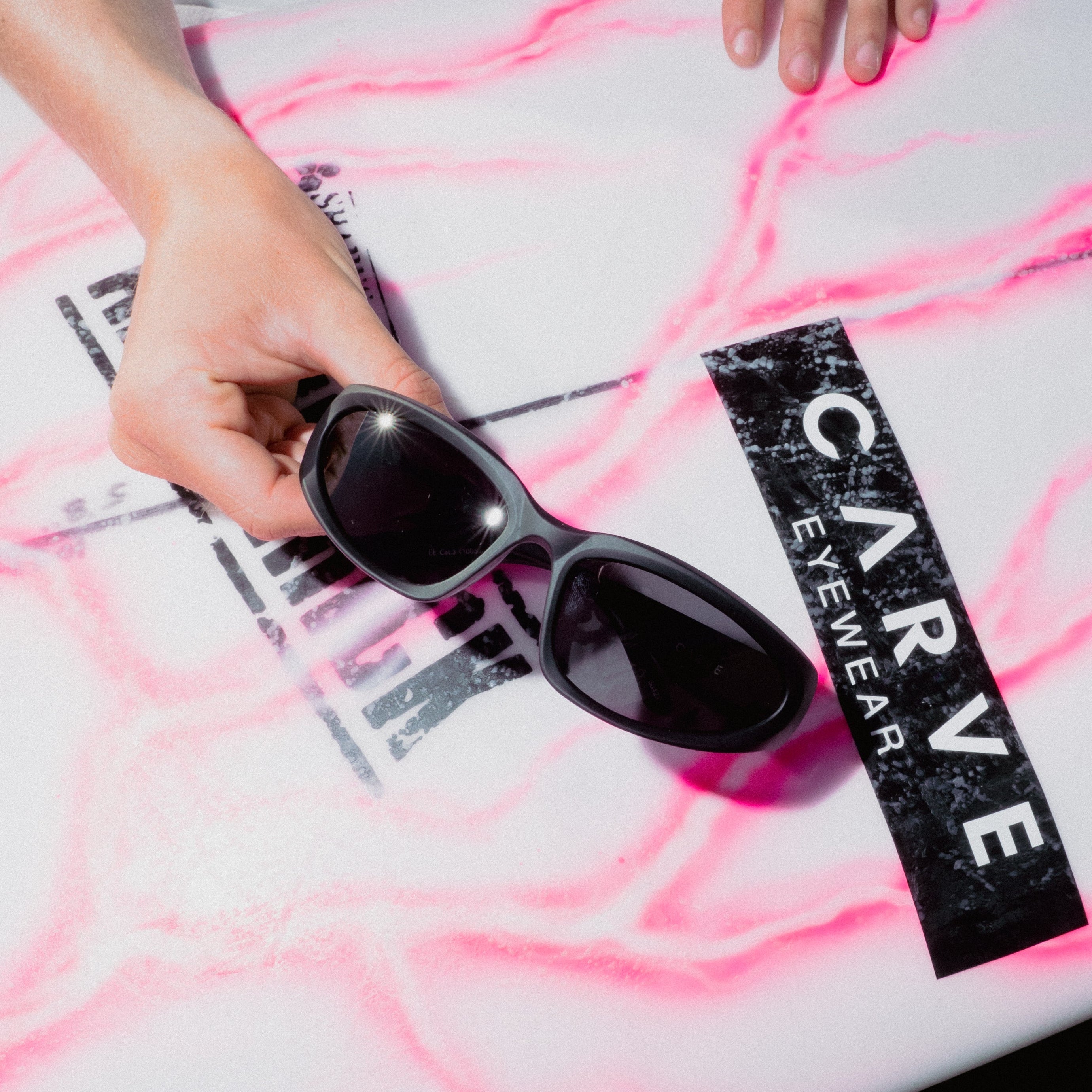 Sunglasses on a surfboard with 'Carve Eyewear' branding