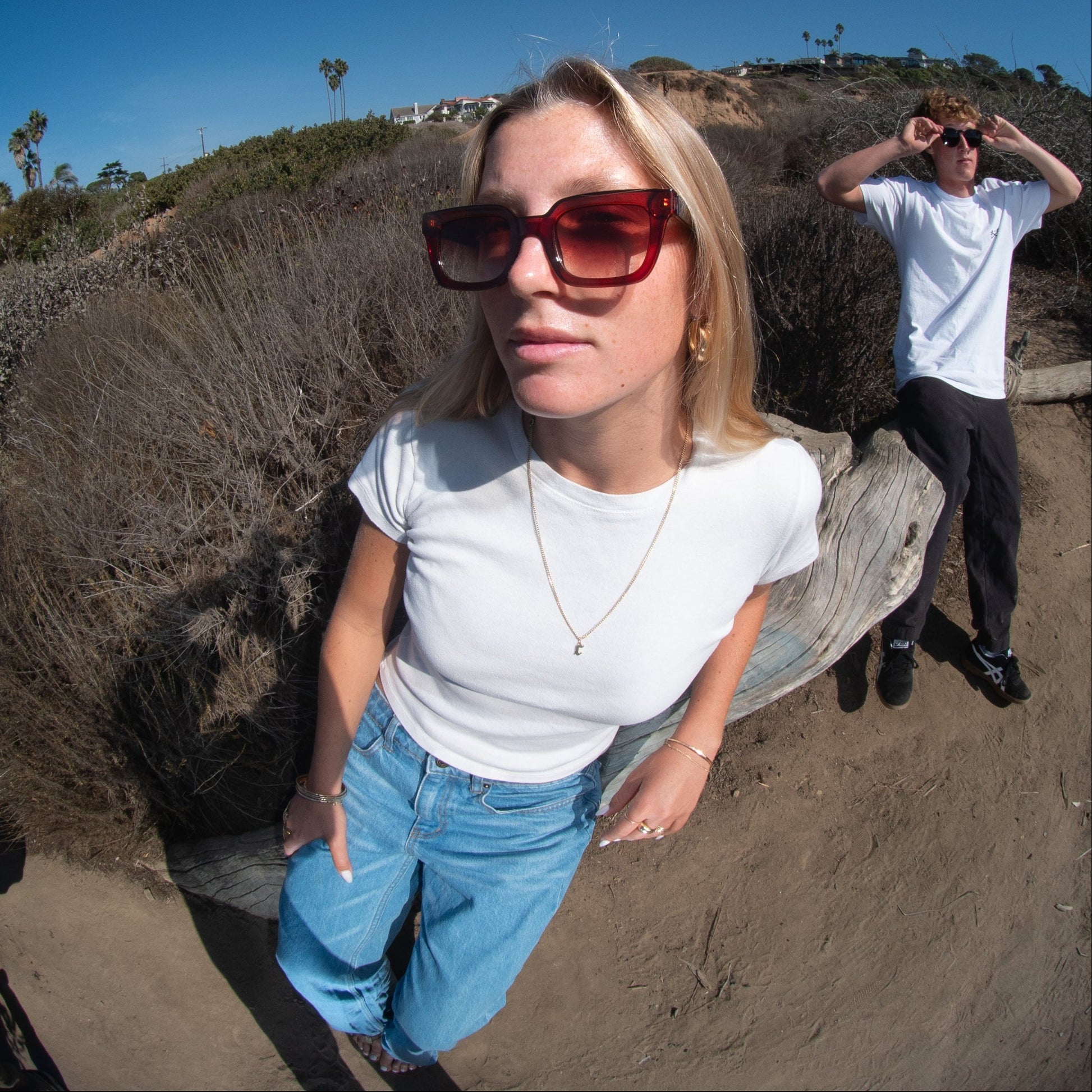 Two people on coastal trail wearing sunglasses