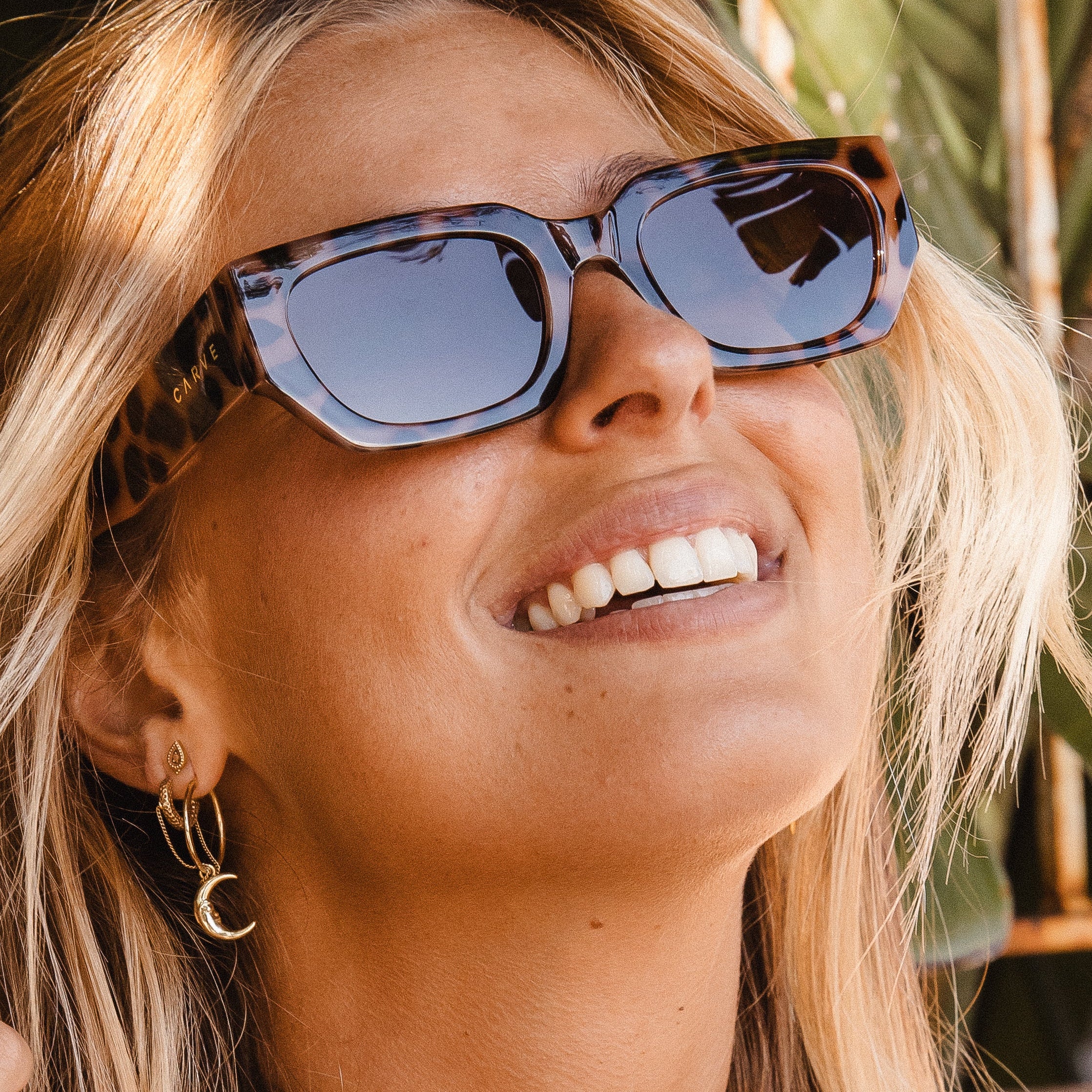 Woman wearing sunglasses with a blurred natural background